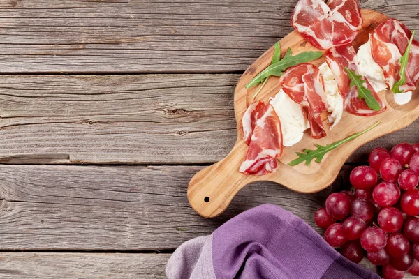 Prosciutto and mozzarella on cutting board — Stock Photo, Image