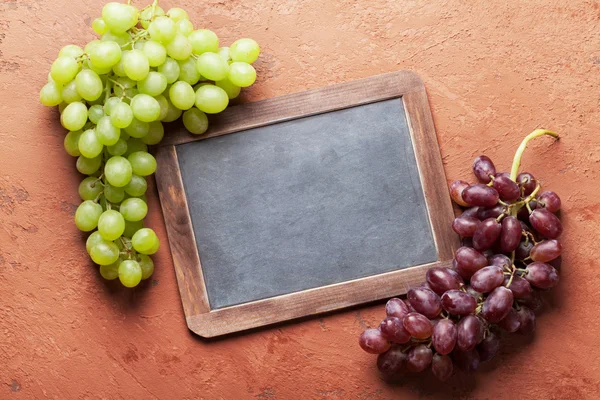 Uvas rojas y blancas y pizarra —  Fotos de Stock