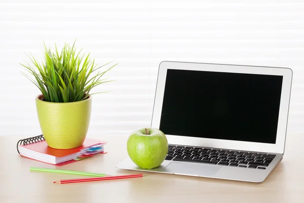 workplace with laptop and supplies