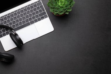 İş masası çalışma yeri ve ofis eşyaları siyah deri arka planda. Üstteki görünüm düzlüğü metin için kopyalama alanı ile yatıyordu