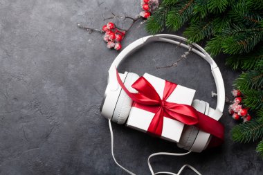 Kulaklıklı ve hediye kutulu Noel tebrik kartı. Üst görünüm düzlüğü kopyalama alanı ile yatıyordu
