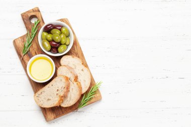 Olgun zeytin, zeytinyağı ve ciabatta ekmeği. Üst görünüm düzlüğü kopyalama alanı ile yatıyordu