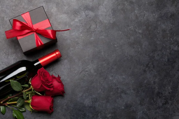 情人节贺卡 用玫瑰花束和红葡萄酒瓶包裹在石头的背景上 为您的问候留出空间 顶视图平铺 — 图库照片