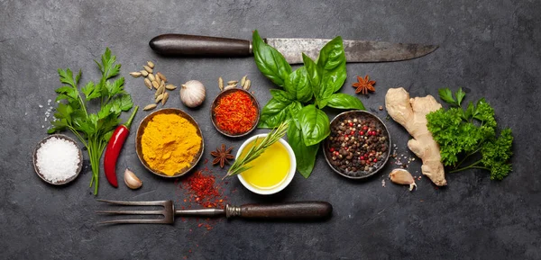 Koyu taş masadaki çeşitli baharatlar, otlar ve baharatlar. Hint mutfağı. Üst görünüm düzlüğü