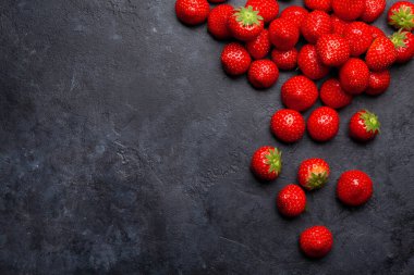 Taş masada olgun bahçe çileği. Üst görünüm düzlüğü kopyalama alanı ile yatıyordu