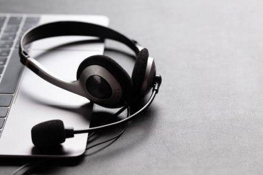 Kulaklık ve dizüstü bilgisayarlı bir ofis masası. Uzaktan ofis ve ev konseptinden çalışma. Kopyalama alanı ile