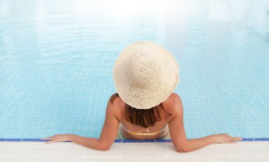 Yaz tatilinde yüzme havuzunda dinlenen bir kadın. Sıcak güneşli tatil konsepti