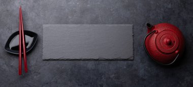 Suşin ve makin için taş tabak ve çubuk. Japon yemek menüsü arka planı. Üst görünüm düzlüğü kopyalama alanı ile yatıyordu