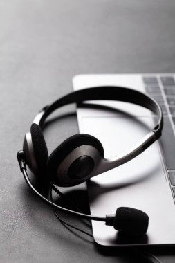 Kulaklık ve dizüstü bilgisayarlı bir ofis masası. Uzaktan ofis ve ev konseptinden çalışma. Kopyalama alanı ile