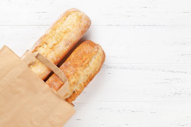 Fransız ekmeği kese kağıdında. Üst görünüm düzlüğü kopyalama alanı ile yatıyordu