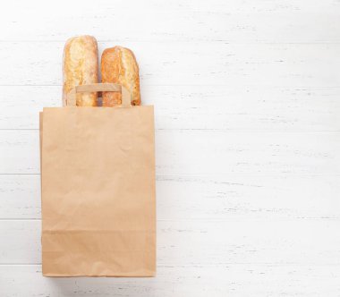 Fransız ekmeği kese kağıdında. Üst görünüm düzlüğü kopyalama alanı ile yatıyordu