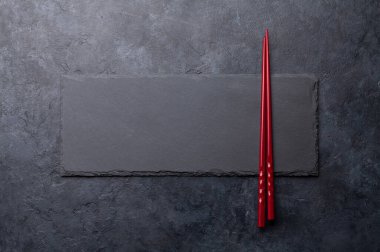 Suşin ve makin için taş tabak ve çubuk. Japon yemek menüsü arka planı. Üst görünüm düzlüğü kopyalama alanı ile yatıyordu