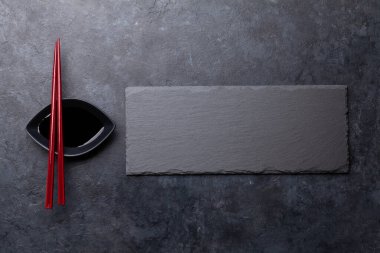 Suşin ve makin için taş tabak ve çubuk. Japon yemek menüsü arka planı. Üst görünüm düzlüğü kopyalama alanı ile yatıyordu