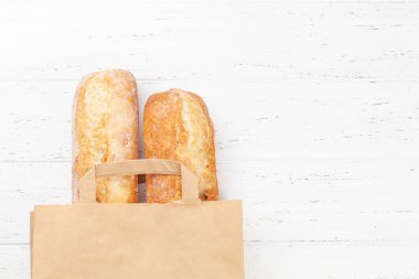 Fransız ekmeği kese kağıdında. Üst görünüm düzlüğü kopyalama alanı ile yatıyordu