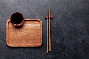 Suşin ve makin için tahta tabak ve çubuk. Japon yemek menüsü arka planı. Üst görünüm düzlüğü kopyalama alanı ile yatıyordu