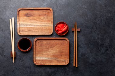 Suşin ve makin için tahta tabaklar ve yemek çubukları. Japon yemek menüsü arka planı. Üst görünüm düzlüğü kopyalama alanı ile yatıyordu