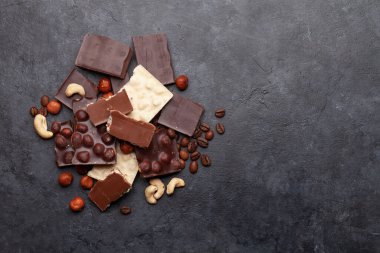 Çeşitli çikolata parçaları, kahve çekirdekleri ve fındıklar. Üst görünüm düzlüğü kopyalama alanı ile yatıyordu