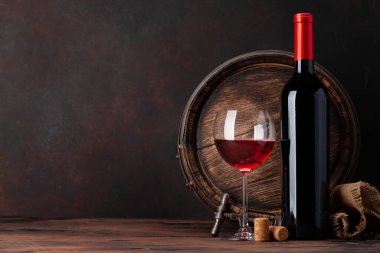 Şarap şişesi, bir kadeh kırmızı şarap ve eski ahşap fıçı. Kopyalama alanı ile