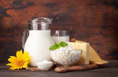 Çeşitli süt ürünleri. Süt, peynir, kulübe, ekşi krema ve yumurta. Kopya alanı ile ahşap arkaplan önünde