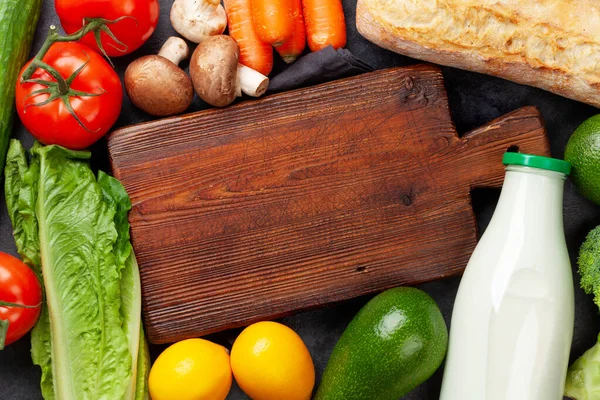 Verschiedenes Gemüse Obst Und Brot Auf Steintisch Und Leerem Schneidebrett — Stockfoto