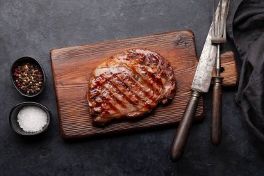 Baharatlı ızgara biftek. Kesme tahtasında. Üst görünüm düzlüğü