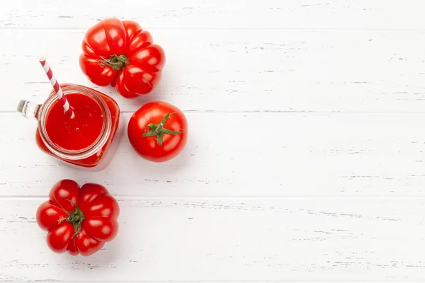 新鮮なトマトジュースと熟したトマトを木製のテーブルに置きます コピースペース付きのトップビュー — ストック写真