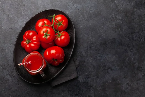 石のテーブルの上に新鮮なトマトジュースと熟したトマト コピースペース付きのトップビュー — ストック写真