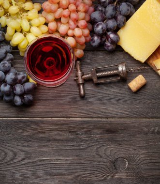 Çeşitli üzümler, bir bardak kırmızı şarap ve peynir. Üst görünüm düzlüğü kopyalama alanı ile yatıyordu