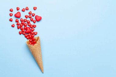 Sevgililer Günü tebrik kartı, üzerinde dondurma külahında kalp şeklinde şekerler var. Üst görünüm düzlüğü kopyalama alanı ile yatıyordu