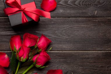 Kırmızı gül çiçekleri ve hediye kutusuyla Sevgililer Günü tebrik kartı. Tebrik etmek için en üstteki dairede yer var.