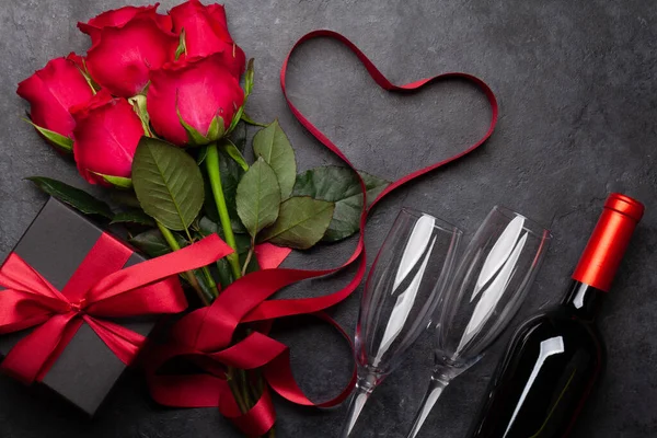 情人节贺卡 红玫瑰花束 酒和礼品盒放在石桌上 顶视图平铺 — 图库照片