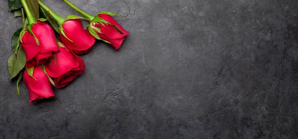 情人节贺卡 红玫瑰花束点缀在深色的石头背景上 俯瞰平面放置有空间供您问候 — 图库照片