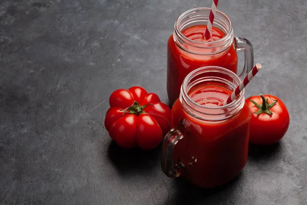 石のテーブルの上に新鮮なトマトジュースと熟したトマト コピースペース付き — ストック写真