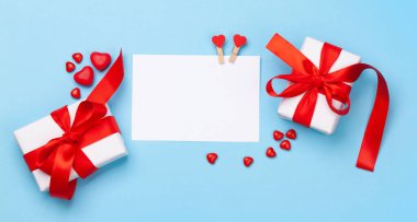 Sevgililer Günü tebrik kartı şablonu. Hediye kutuları, kalp dekoru ve mavi arka planda şekerleme. Üst görünüm düzlüğü kopyalama alanı ile yatıyordu