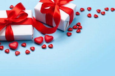 Sevgililer Günü tebrik kartı şablonu. Hediye kutuları, kalp şekerleri mavi arka planda. Kopyalama alanı ile