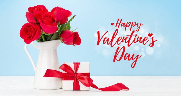 Открытки на день Святого Валентина с букетом из красных роз и подарочной коробкой на деревянном столе