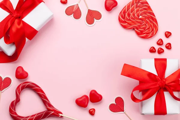 バレンタインデーグリーティングカードテンプレート ギフトボックス ハートの装飾 ピンクの背景にキャンディスイーツ コピースペース付きのトップビューフラットレイ — ストック写真