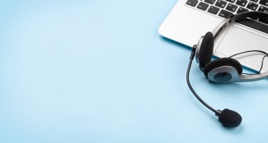 Kulaklık ve dizüstü bilgisayarlı bir ofis masası. Uzaktan ofis ve ev konseptinden çalışma. Kopyalama alanı ile