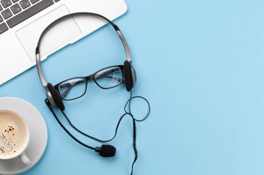 Kulaklık, bardak, kahve ve dizüstü bilgisayarlı ofis masası. Uzaktan ofis ve ev konseptinden çalışma. Kopyalama alanı ile
