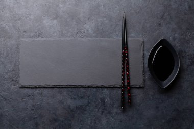 Suşin ve makin için taş tabak ve çubuk. Japon yemek menüsü arka planı. Üst görünüm düzlüğü kopyalama alanı ile yatıyordu