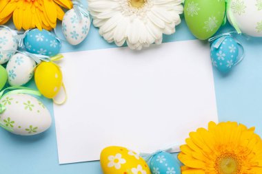 İçinde Gerbera çiçekleri ve renkli paskalya yumurtaları olan Paskalya tebrik kartı. Tebrik etmek için en üstteki dairede yer var.