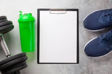 Spor ayakkabıları ve dambıllar. Spor, fitness ve sağlıklı yaşam tarzı. Üst görünüm düzlüğü kopyalama alanı ile yatıyordu