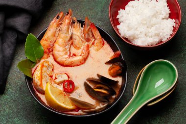 Geleneksel Tayland çorbası Tom Yum kung deniz ürünleri, hindistan cevizi sütü, biber ve pirinç kasesi.