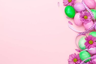 Renkli paskalya yumurtaları ve çiçeklerle dolu Paskalya tebrik kartı. Tebrik etmek için en üstteki dairede yer var.