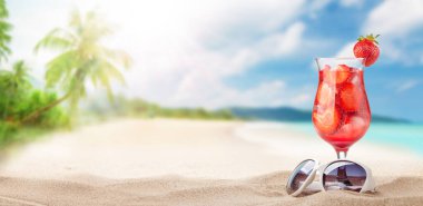 Tropikal sahilde palmiyeler ve parlak kumlarla taze soğuk kokteyl. Yaz tatili ve seyahat konsepti