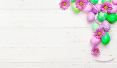 Renkli paskalya yumurtaları ve çiçeklerle dolu Paskalya tebrik kartı. Tebrik etmek için en üstteki dairede yer var.