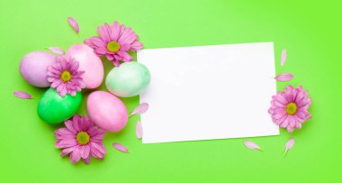 Renkli paskalya yumurtaları ve çiçeklerle dolu Paskalya tebrik kartı. Tebrik etmek için en üstteki dairede yer var.