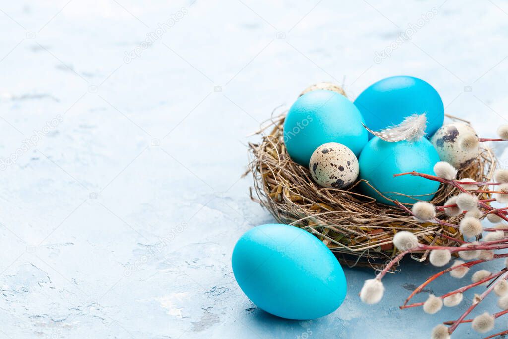 Colorful easter eggs in nest on stone background. With space for your greetings