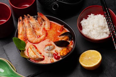 Geleneksel Tayland çorbası Tom Yum kung deniz ürünleri, hindistan cevizi sütü, biber ve pirinç kasesi.