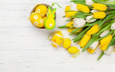 Paskalya tebrik kartı, üzerinde paskalya yumurtaları ve lale çiçekleri var. Üst görünüm düzlüğü kopyalama alanı ile yatıyordu